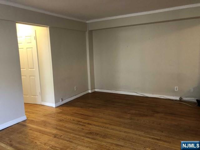 2205 North Central Road, Unit 5A Fort Lee, NJ 07024 - Photo 7 of 24 a view of an empty room with wooden floor and a window