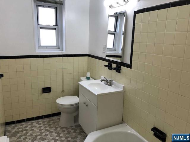 2205 North Central Road, Unit 5A Fort Lee, NJ 07024 - Photo 8 of 24 a bathroom with a toilet sink and mirror