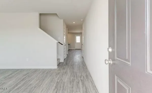 a view of a hallway with wooden floor and staircase
