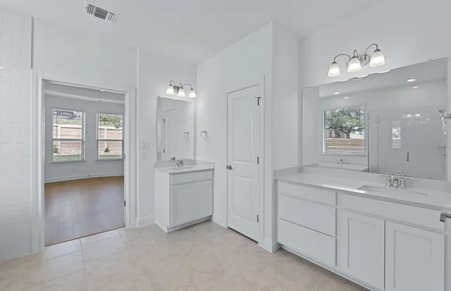 a bathroom with a double vanity sink and a mirror