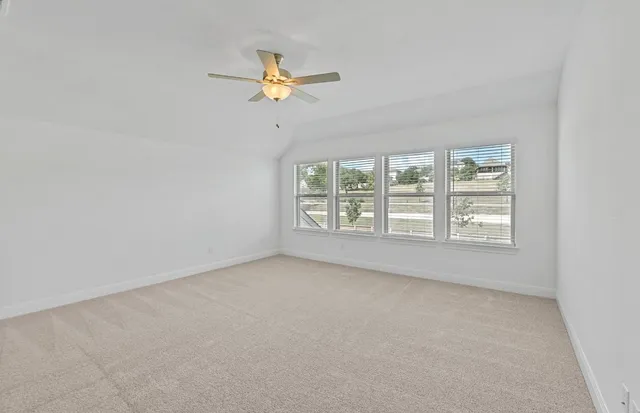 an empty room with windows and fan
