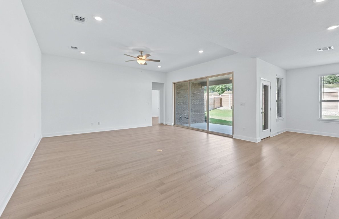3109 Delaware Street Leander, TX 78641 - Photo 5 of 21 an empty room with wooden floor and windows