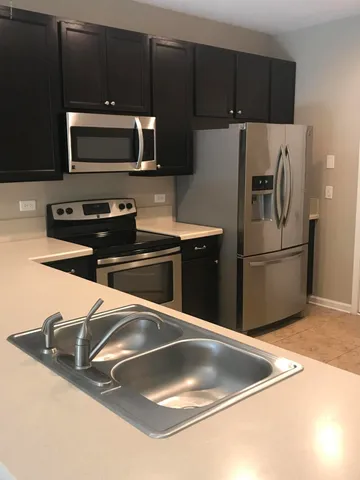 a kitchen with granite countertop a refrigerator a stove and a sink