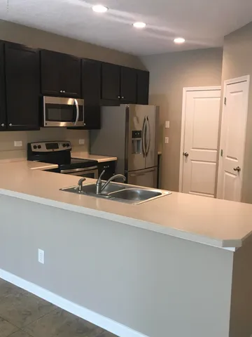 a kitchen with stainless steel appliances a refrigerator sink and microwave