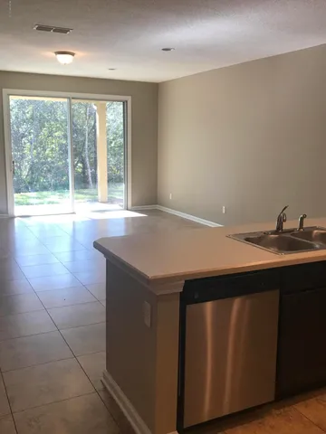 a kitchen with a sink a large window and a wooden floor