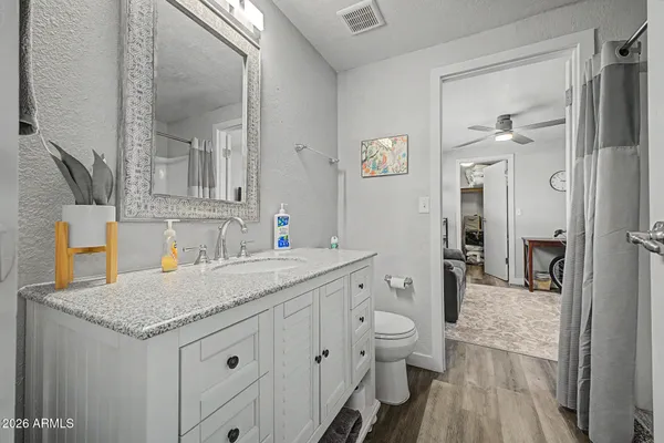a bathroom with a granite countertop sink mirror vanity and toilet