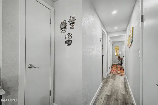 a hallway with white cabinets and wooden floor