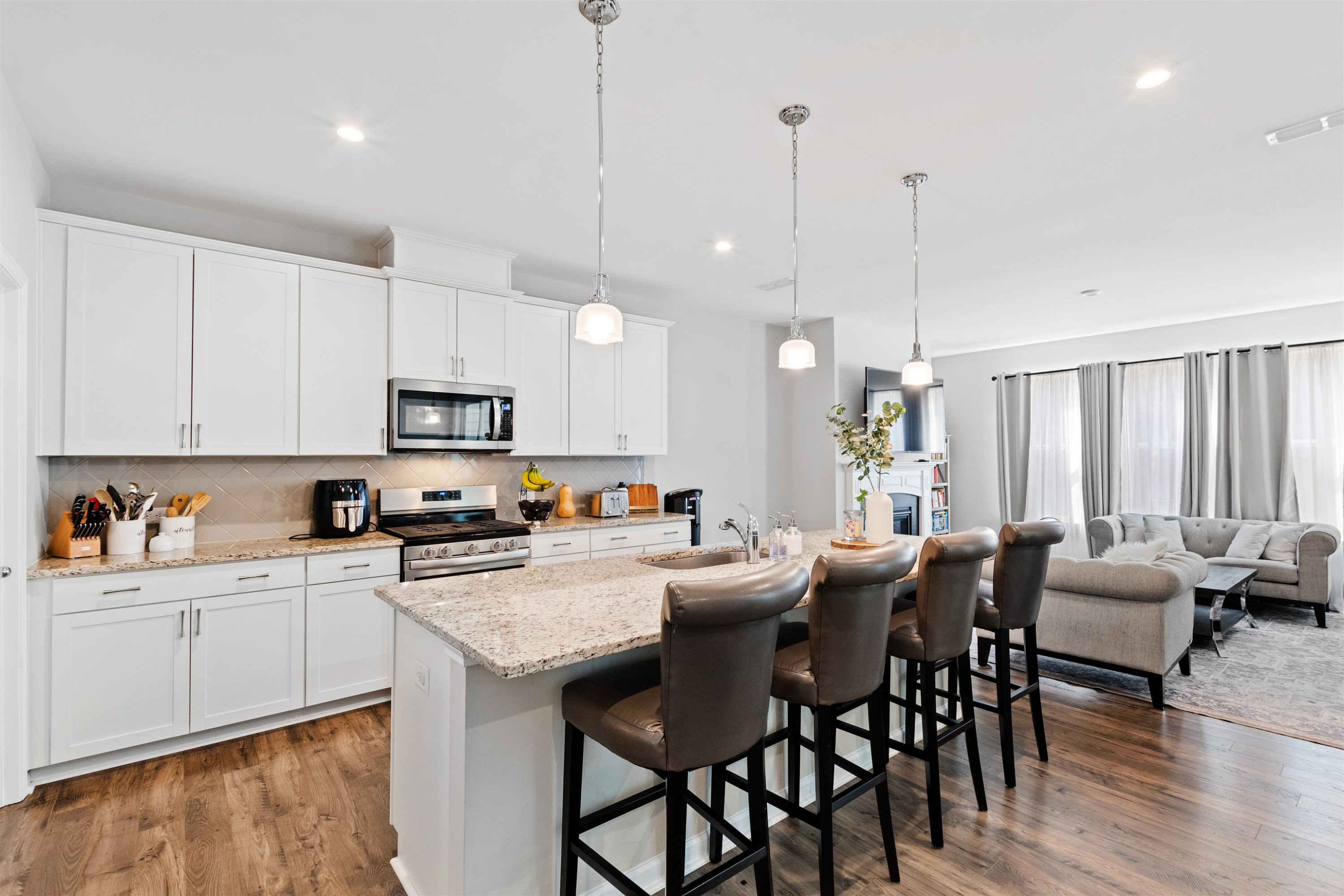 1636 Brussels Drive Apex, NC 27502 - Photo 13 of 35 a kitchen with kitchen island granite countertop a table chairs sink and cabinets