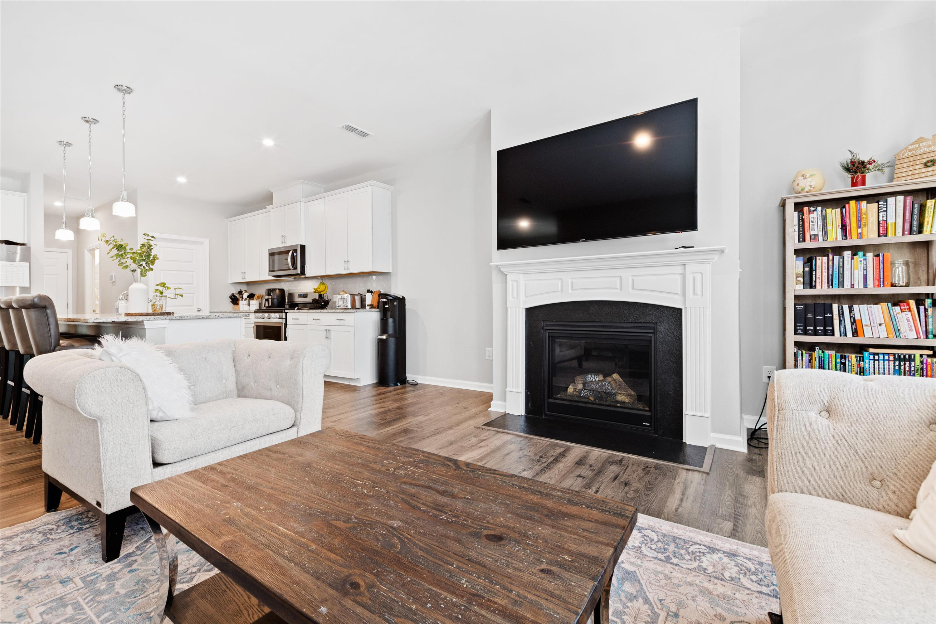 1636 Brussels Drive Apex, NC 27502 - Photo 15 of 35 a living room with furniture a fireplace and a flat screen tv