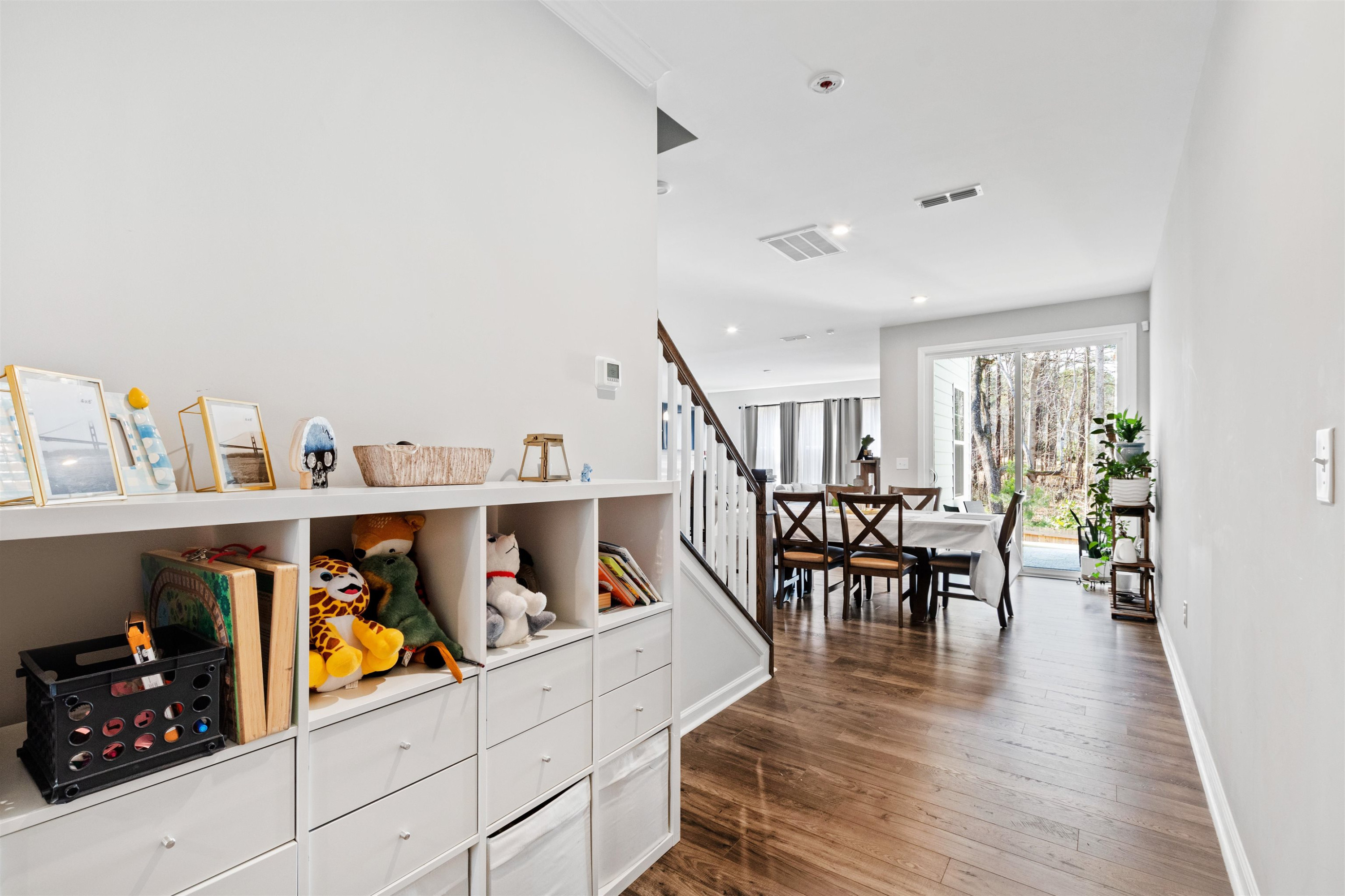 1636 Brussels Drive Apex, NC 27502 - Photo 3 of 35 a hallway with wooden floor and baby crib