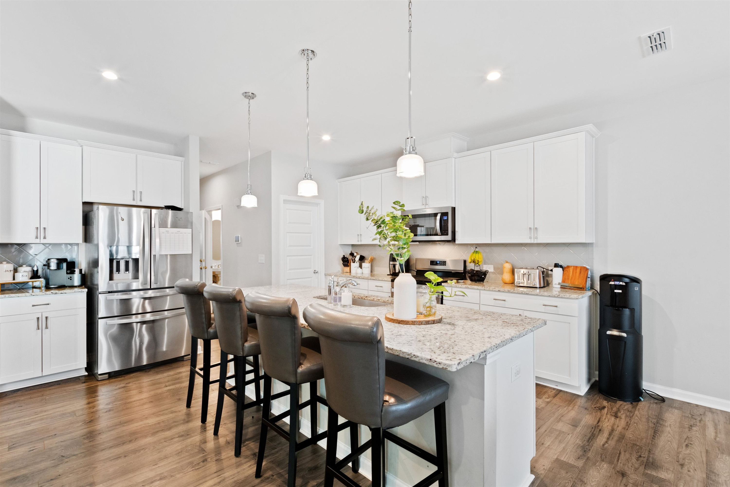 1636 Brussels Drive Apex, NC 27502 - Photo 7 of 35 a kitchen with stainless steel appliances a dining table chairs stove refrigerator and microwave