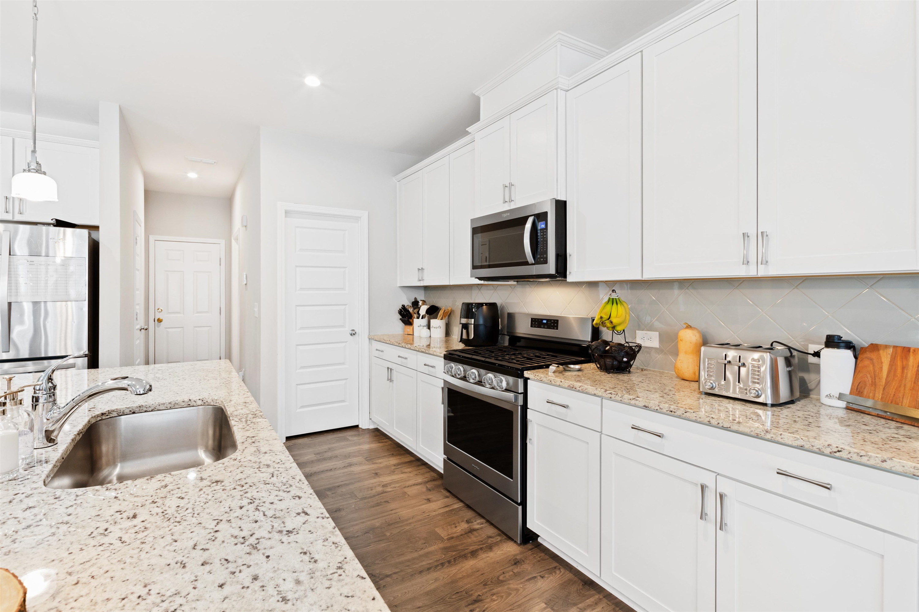 1636 Brussels Drive Apex, NC 27502 - Photo 8 of 35 a kitchen with granite countertop a sink a stove and cabinets