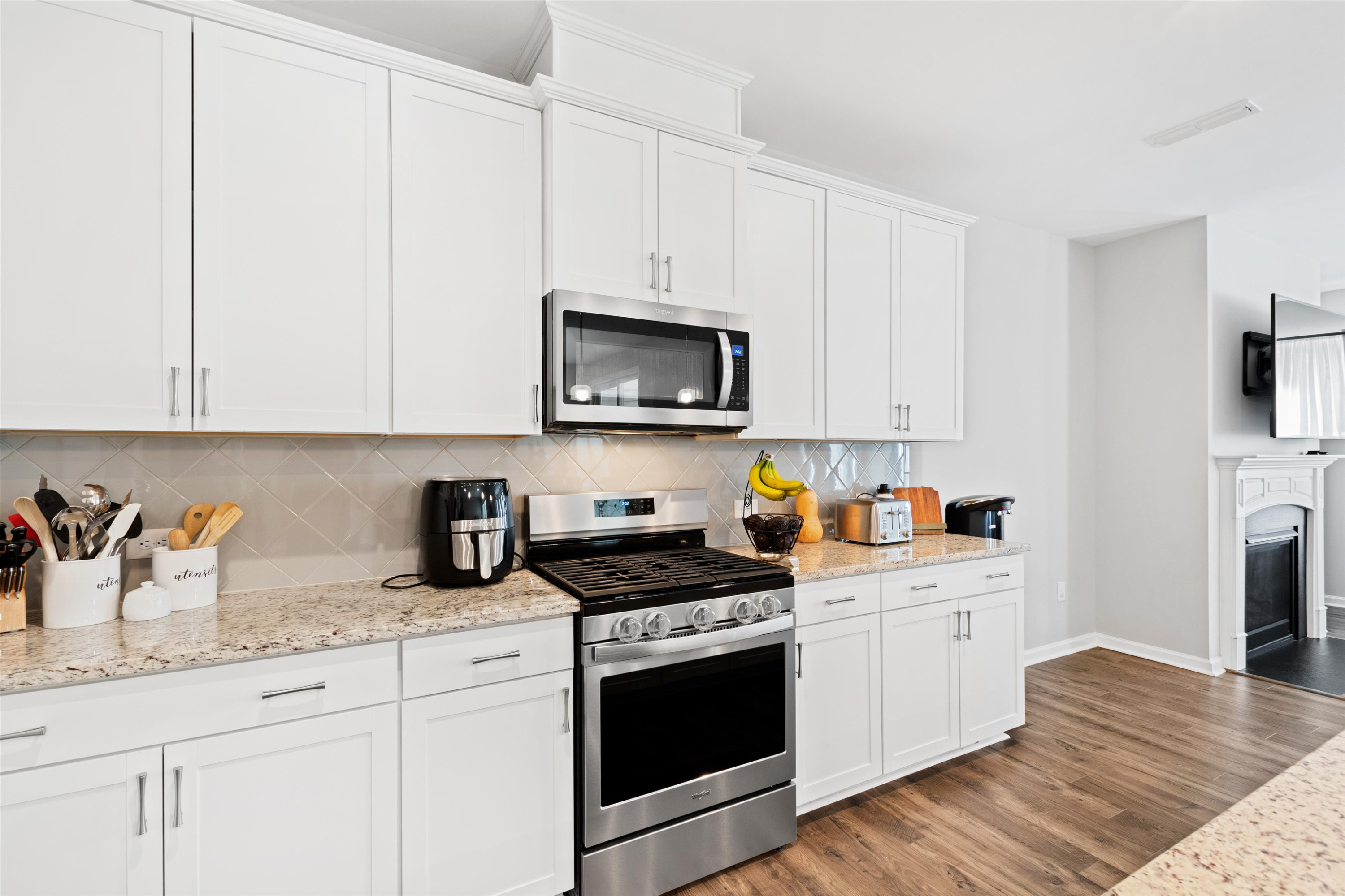 1636 Brussels Drive Apex, NC 27502 - Photo 10 of 35 a kitchen with granite countertop white cabinets sink and stainless steel appliances