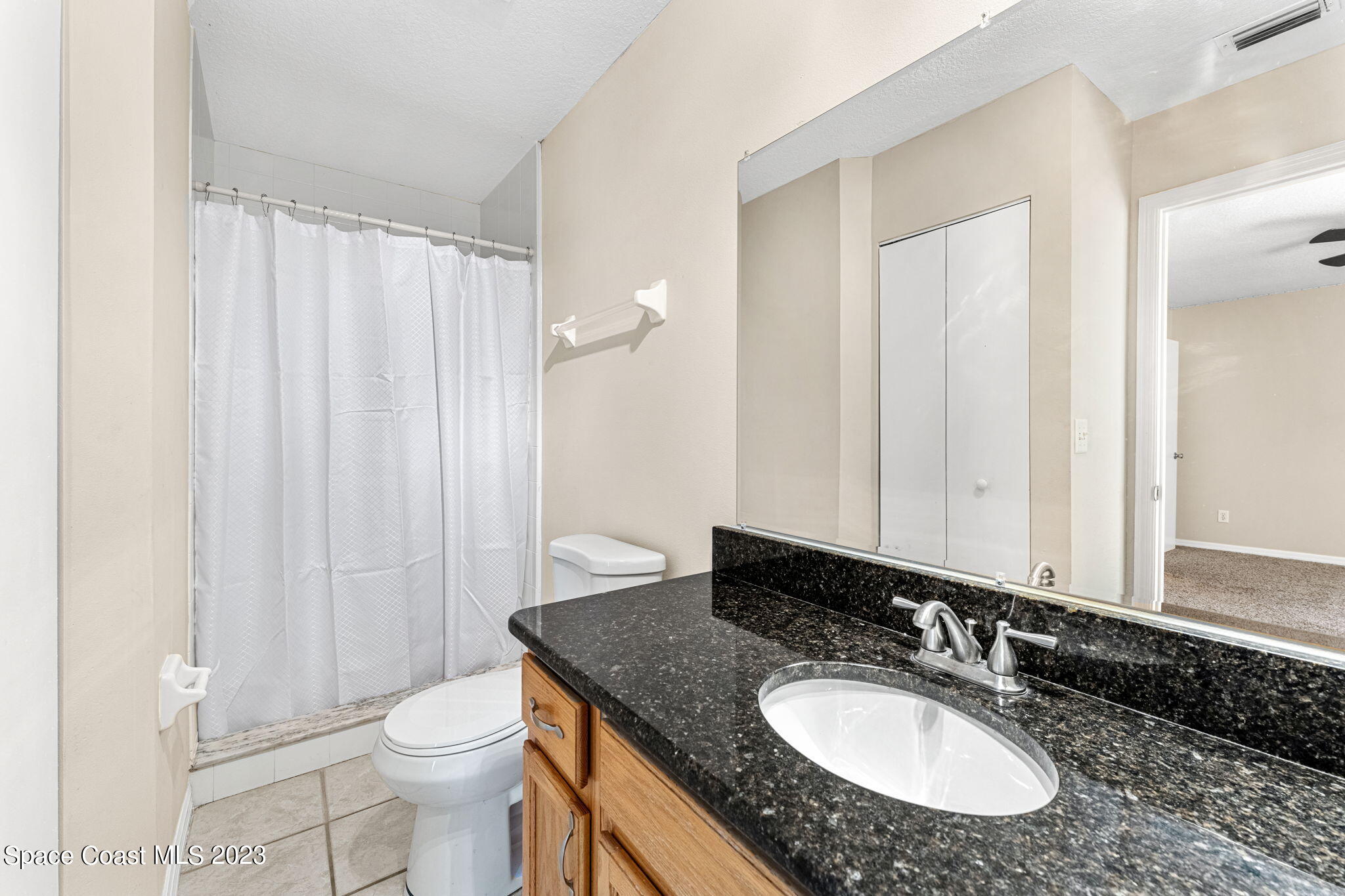 2717 Manor Drive Northeast Palm Bay, FL 32905 - Photo 11 of 21 a bathroom with a granite countertop sink and a mirror with toilet