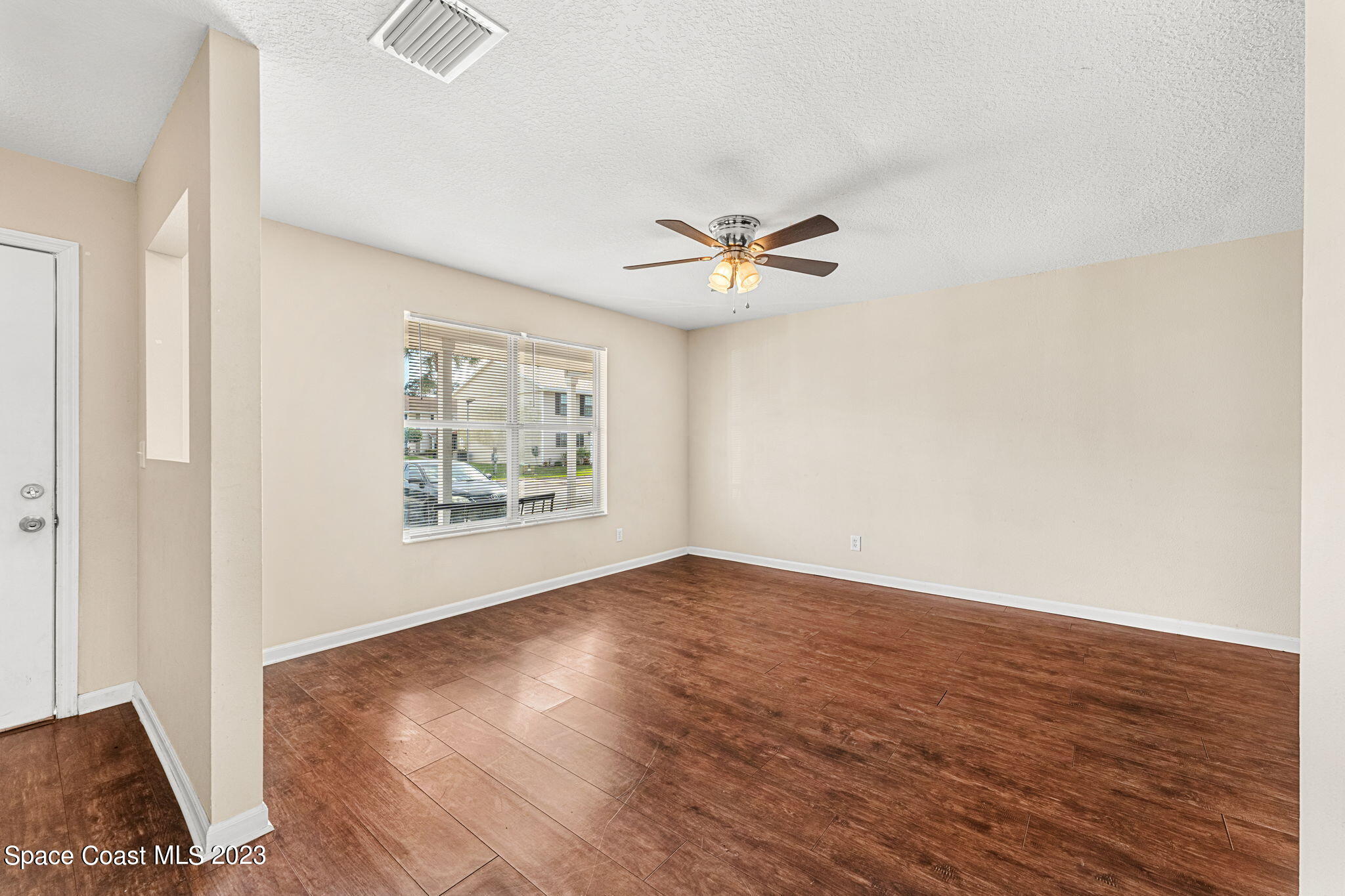 2717 Manor Drive Northeast Palm Bay, FL 32905 - Photo 2 of 21 an empty room with wooden floor and window