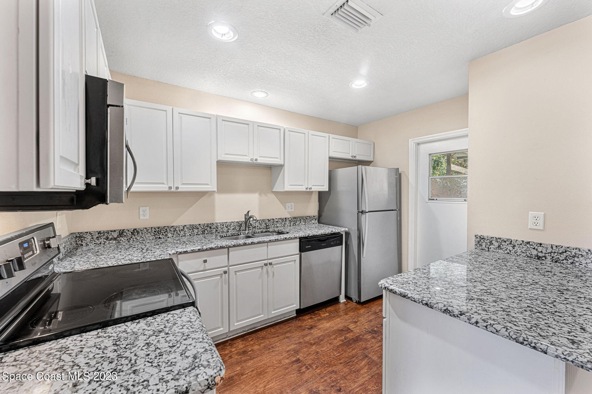 2717 Manor Drive Northeast Palm Bay, FL 32905 - Photo 5 of 21 a kitchen with stainless steel appliances granite countertop a sink stove and refrigerator
