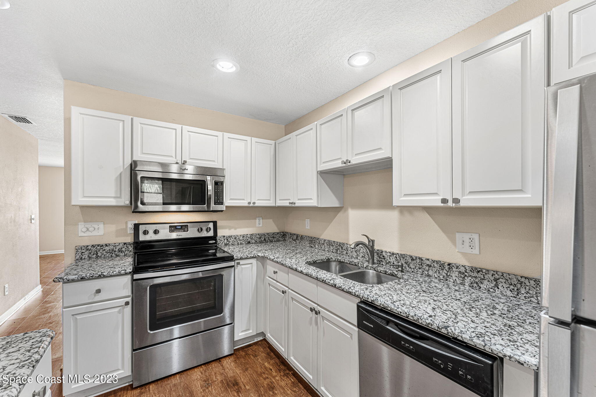 2717 Manor Drive Northeast Palm Bay, FL 32905 - Photo 6 of 21 a kitchen with stainless steel appliances granite countertop a stove a sink and a microwave