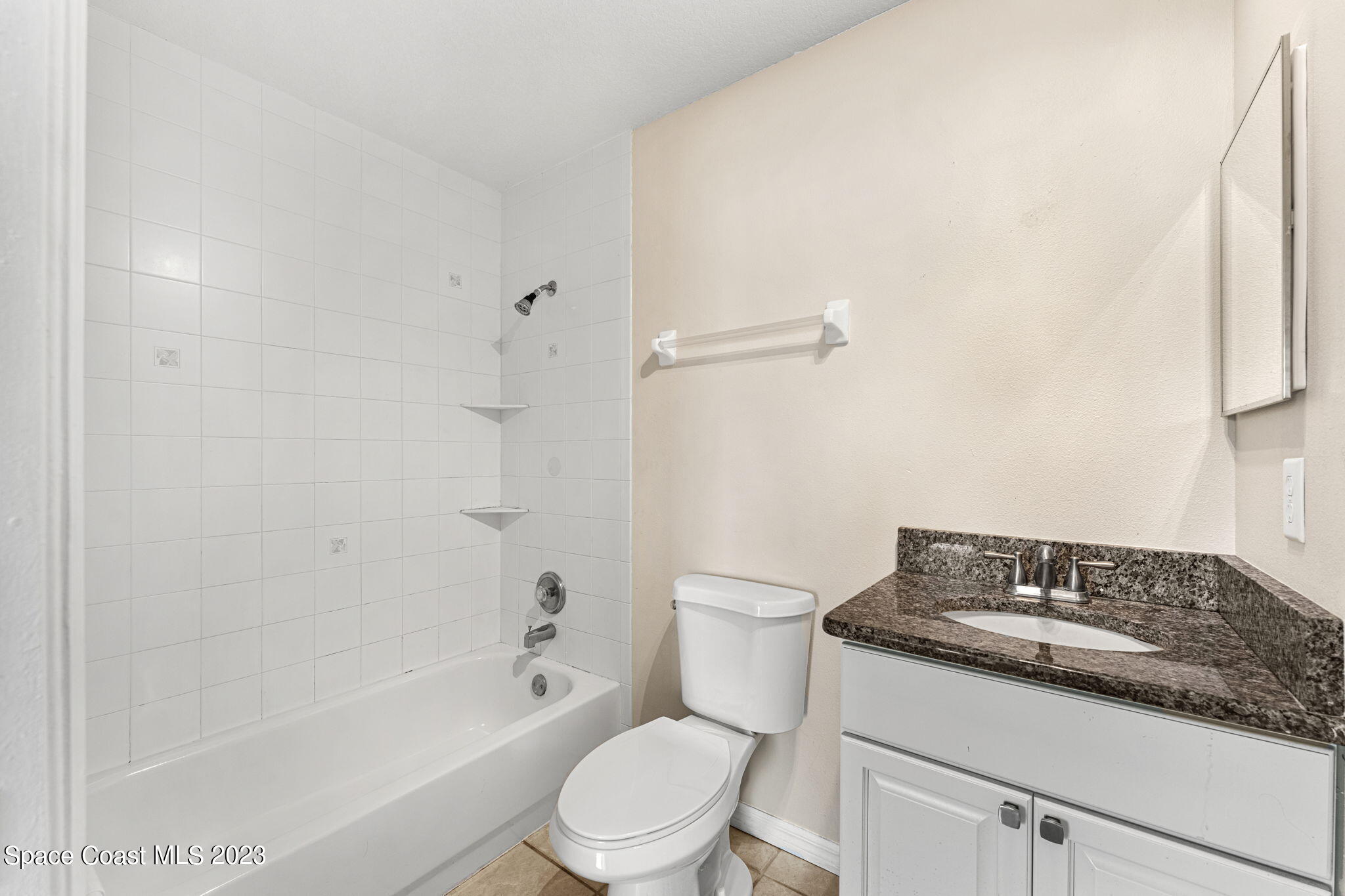 2717 Manor Drive Northeast Palm Bay, FL 32905 - Photo 9 of 21 a bathroom with a granite countertop toilet a sink and bathtub