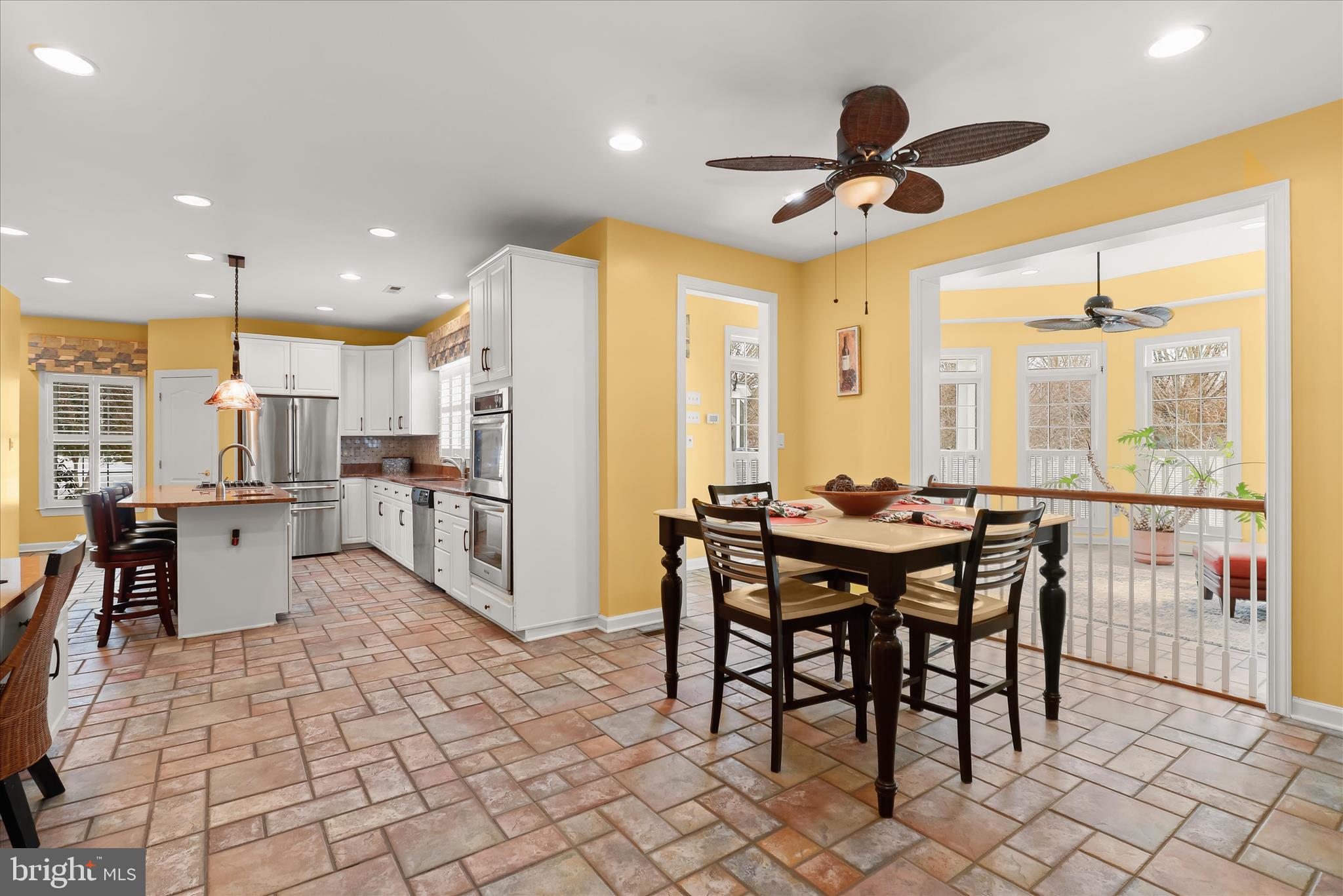 8061 Hunterbrooke Lane Fulton, MD 20759 - Photo 17 of 90 a kitchen with stainless steel appliances kitchen island granite countertop a table chairs and a refrigerator