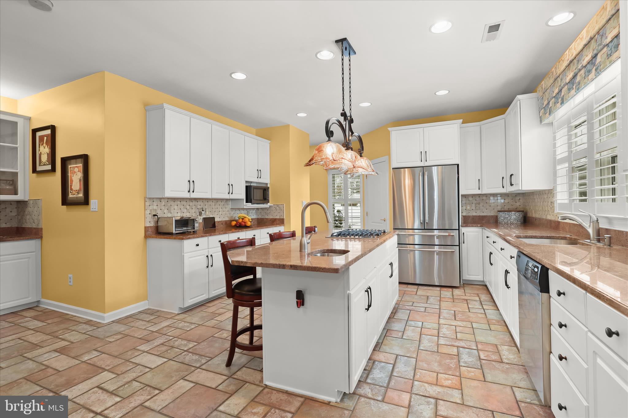 8061 Hunterbrooke Lane Fulton, MD 20759 - Photo 19 of 90 a kitchen with stainless steel appliances kitchen island granite countertop a refrigerator a stove and white cabinets with wooden floors