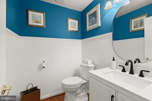 a bathroom with a granite countertop sink a light fixture and a mirror