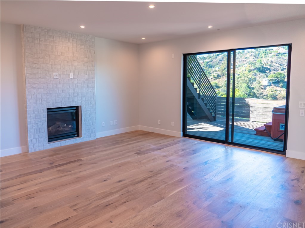 8184 Mannix Drive Los Angeles, CA 90046 - Photo 15 of 53 a view of an empty room with wooden floor and a fireplace