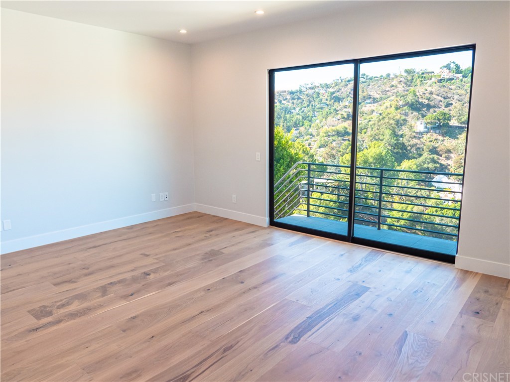 8184 Mannix Drive Los Angeles, CA 90046 - Photo 21 of 53 an empty room with wooden floor and windows