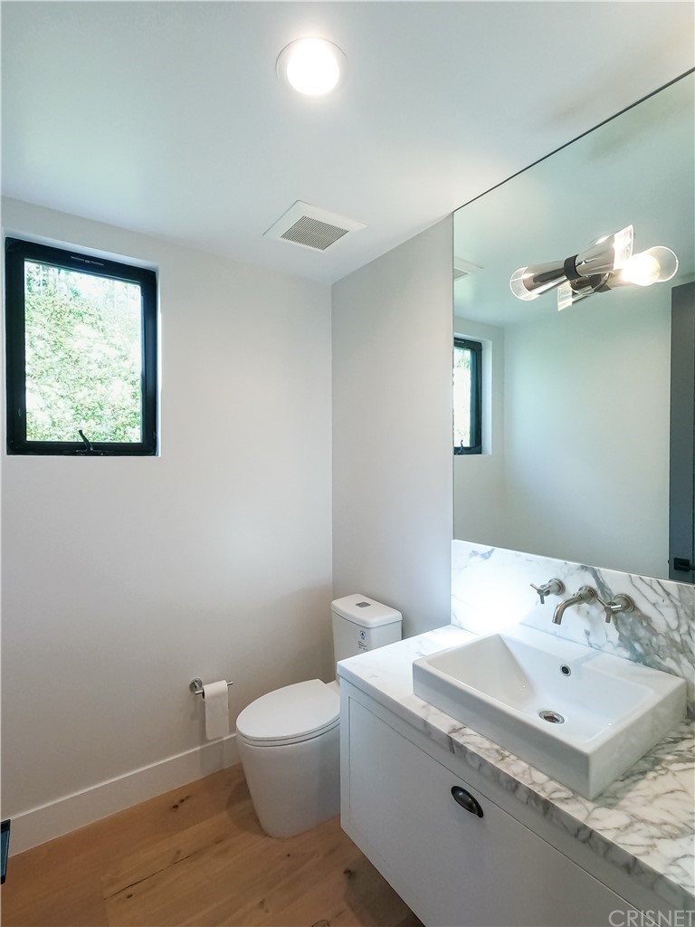 8184 Mannix Drive Los Angeles, CA 90046 - Photo 28 of 53 a bathroom with a toilet a sink and mirror
