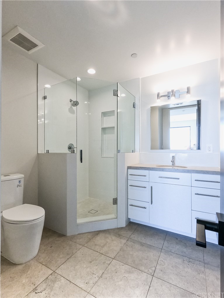 8184 Mannix Drive Los Angeles, CA 90046 - Photo 51 of 53 a bathroom with a granite countertop sink a toilet and a mirror
