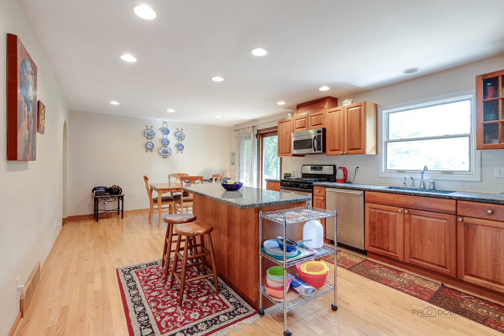 260 North St Marys Road Libertyville, IL 60048 - Photo 9 of 34 a open kitchen with stainless steel appliances granite countertop a stove a sink dishwasher and a dining table with wooden floor