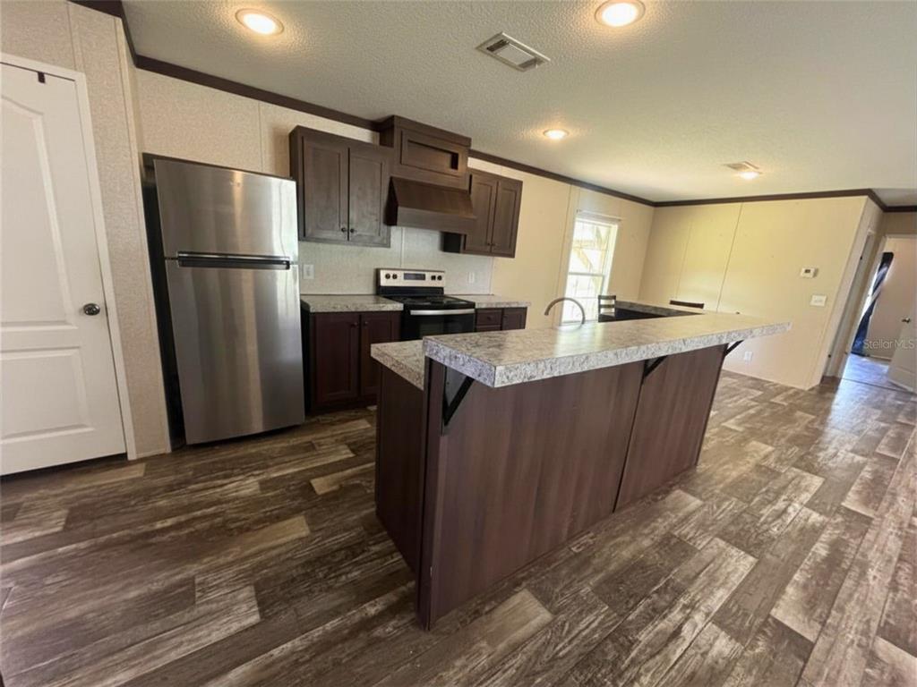 9827 Southeast Hoth Road Arcadia, FL 34266 - Photo 15 of 28 a kitchen with stainless steel appliances granite countertop a refrigerator a sink a stove a microwave and island