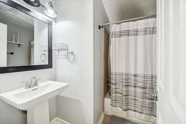 a bathroom with a sink a mirror and shower