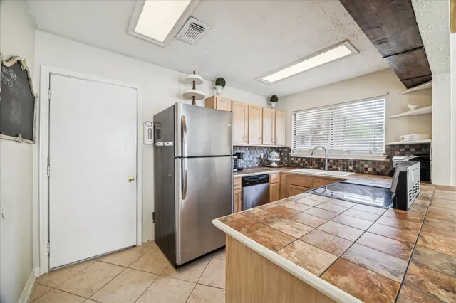 a kitchen with stainless steel appliances granite countertop a refrigerator and a sink