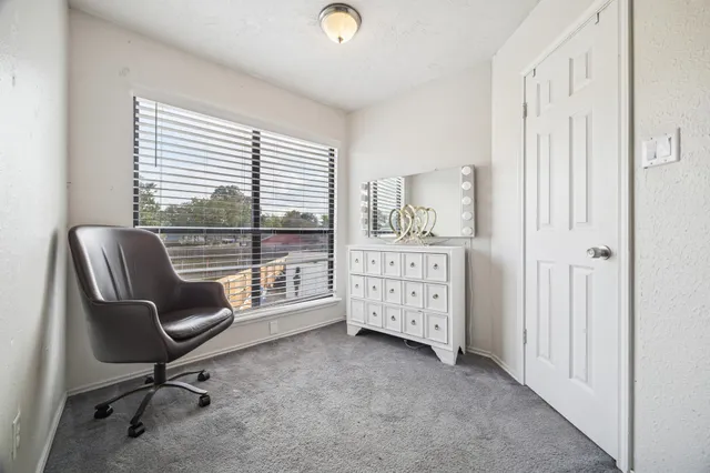 a view of a workspace with furniture and a window