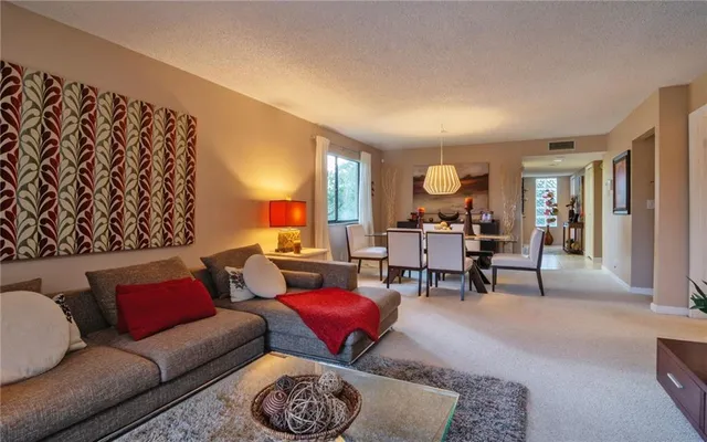 a living room with furniture a rug and a painting on the wall