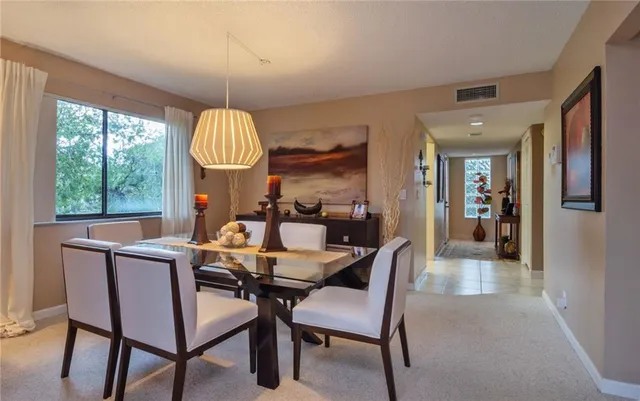 a dining room with furniture a chandelier and window