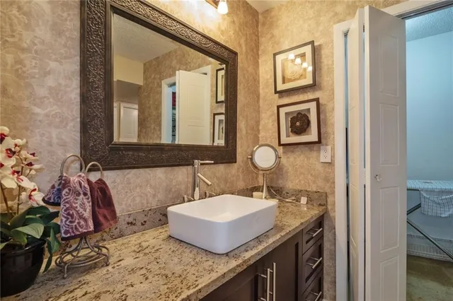 a bathroom with a granite countertop sink and a mirror