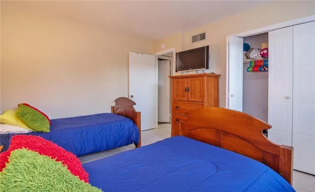 a bedroom with two bed and a flat screen tv