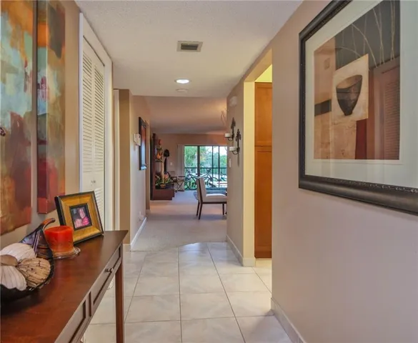 a view of a hallway with workspace and a window