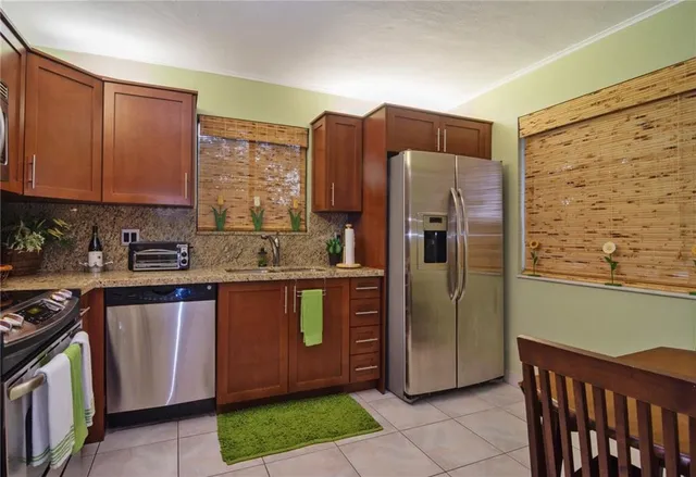 a kitchen with stainless steel appliances granite countertop a refrigerator and a sink