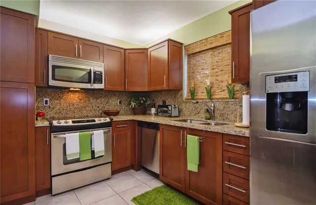 a kitchen with stainless steel appliances granite countertop a stove microwave and sink