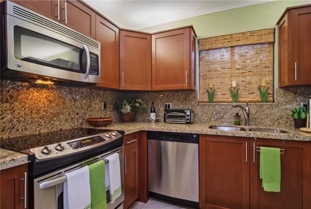a kitchen with stainless steel appliances a stove sink and microwave