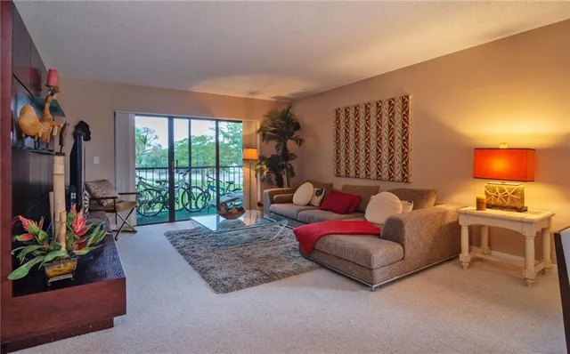 a living room with furniture a flat screen tv and a floor to ceiling window