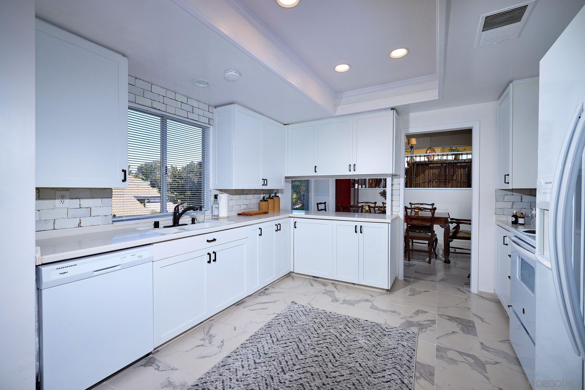 2035 Caminito Circulo Sur La Jolla, CA 92037 - Photo 10 of 22 a kitchen with white cabinets and appliances
