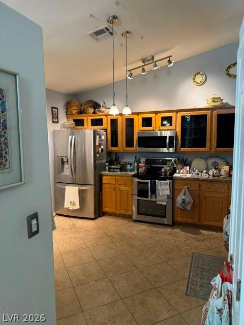 589 Beacon Ridge Way Mesquite, NV 89027 - Photo 9 of 18 A functional kitchen boasts warm wooden cabinetry paired with sleek stainless steel appliances, grounded by practical tile flooring.