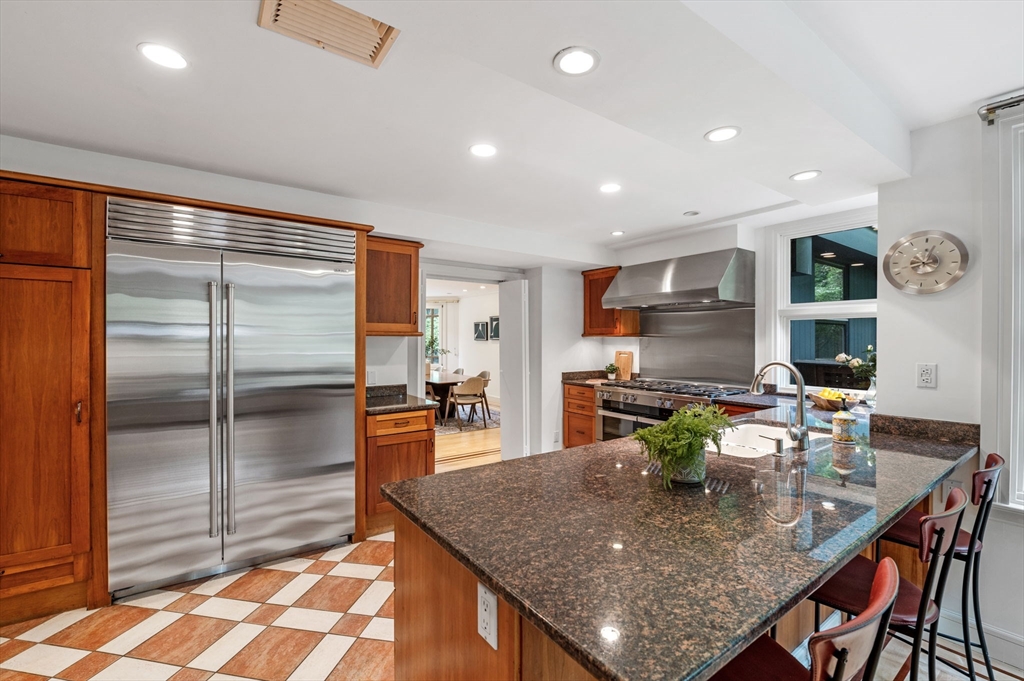 18 Hemlock Road Cambridge, MA 02138 - Photo 15 of 26 a kitchen with stainless steel appliances granite countertop a refrigerator a stove a sink a dining table and chairs with wooden floor