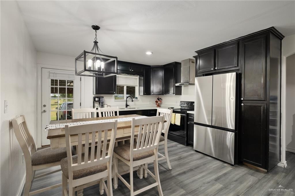 4204 Lott Road Donna, TX 78537 - Photo 4 of 15 a kitchen with stainless steel appliances a refrigerator a stove a sink a dining table and chairs