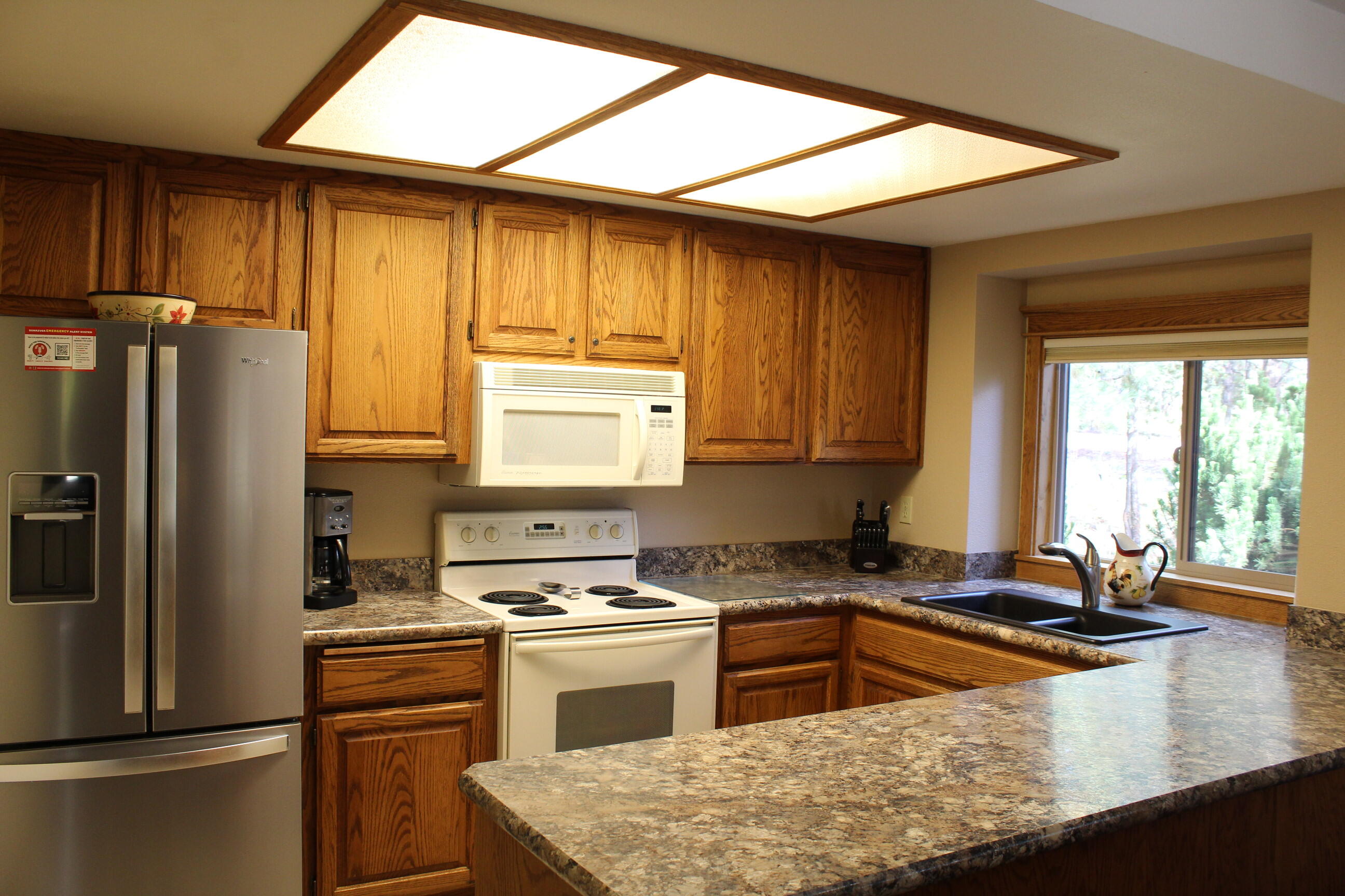 57307 Beaver Ridge Loop, Unit 7C Sunriver, OR 97707 - Photo 10 of 21 a kitchen with a refrigerator a stove a sink and a window
