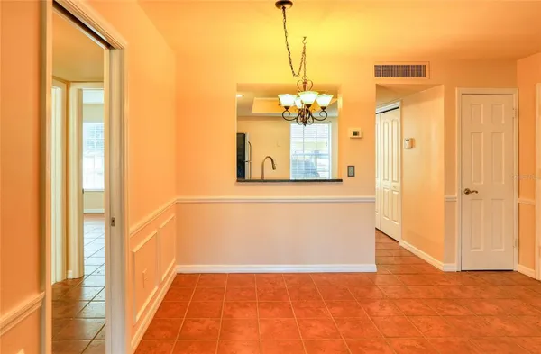 a view of a hallway with wooden floor and a chandelier