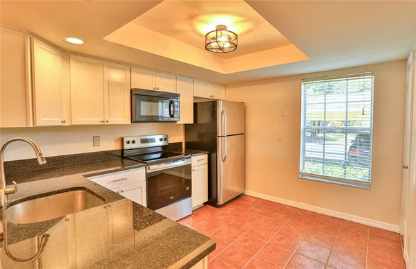 a kitchen with stainless steel appliances granite countertop a stove a sink and a microwave